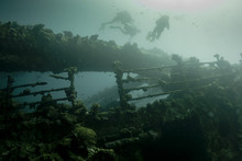 Scuba Divers Exploring A Ship Wreck In Red Sea
