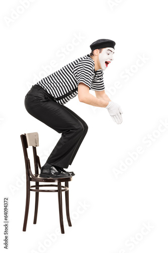 Fotografie, Obraz Male comedian jumping from a chair