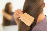 Closeup on young woman combing hair