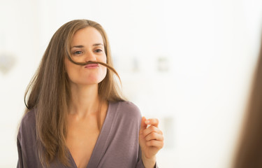 Happy young woman playing with hair