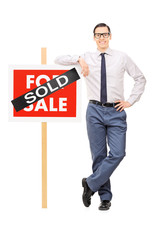 Poster - Male real estate agent leaning on a sold sign