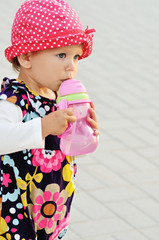 Wall Mural - baby girl drinking water