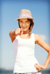 Poster - girl in hat pointing at you on the beach