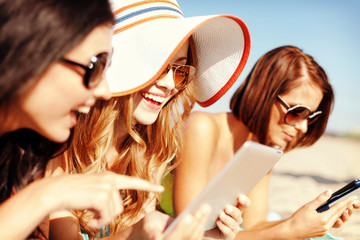 Poster - girls with tablet pc on the beach