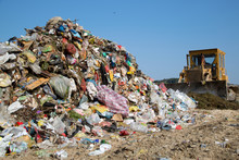 The Old Bulldozer Moving Garbage In A Landfill
