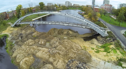 construction of pedestrian arch bridge over small river