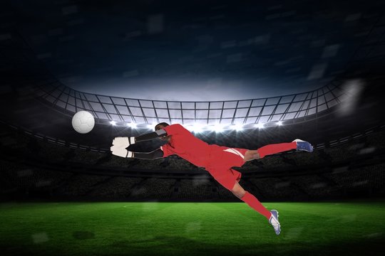 Composite image of goalkeeper in red making a save