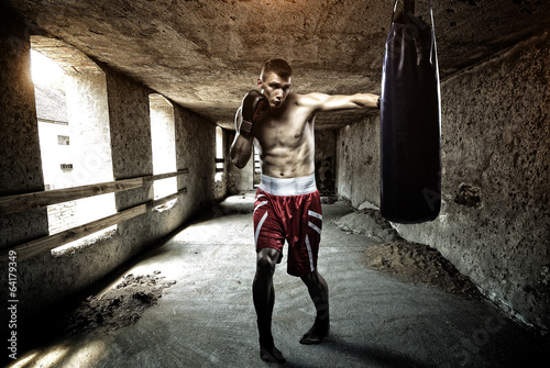 Leinwand Poster Young man boxing workout in an old building
