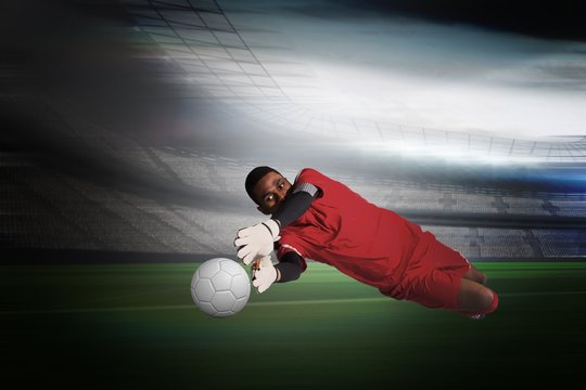 Composite image of goalkeeper in red making a save