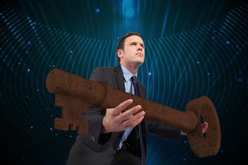 Poster - Composite image of businessman carrying large key