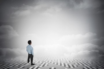 Poster - Composite image of businessman standing with hands in pockets