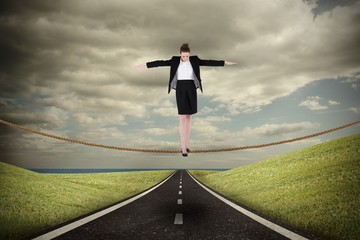 Poster - Composite image of businesswoman performing a balancing act