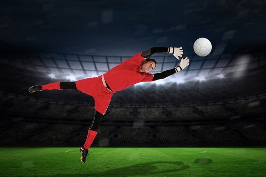 Composite image of fit goal keeper jumping up