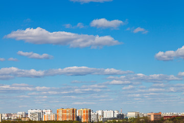 Canvas Print - white clouds in blue sky over urban district