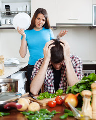  Unhappy man with angry wife at home kitchen