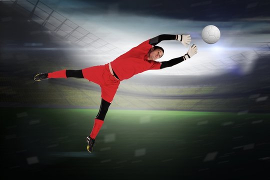 Composite image of fit goal keeper jumping up