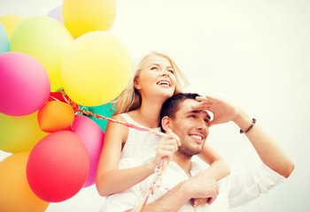 Canvas Print - couple with colorful balloons at seaside