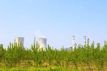 coal fired power station with cooling towers releasing steam int