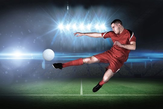 Composite image of fit football player playing and kicking