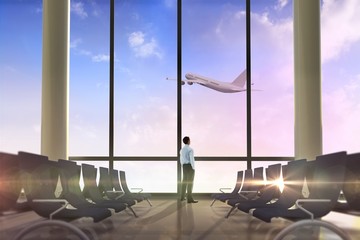 Poster - Composite image of businessman standing with hands in pockets