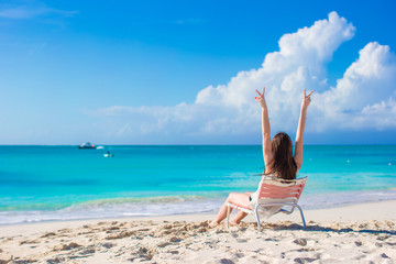 Wall Mural - Young happy woman in a beach chair on summer vacation