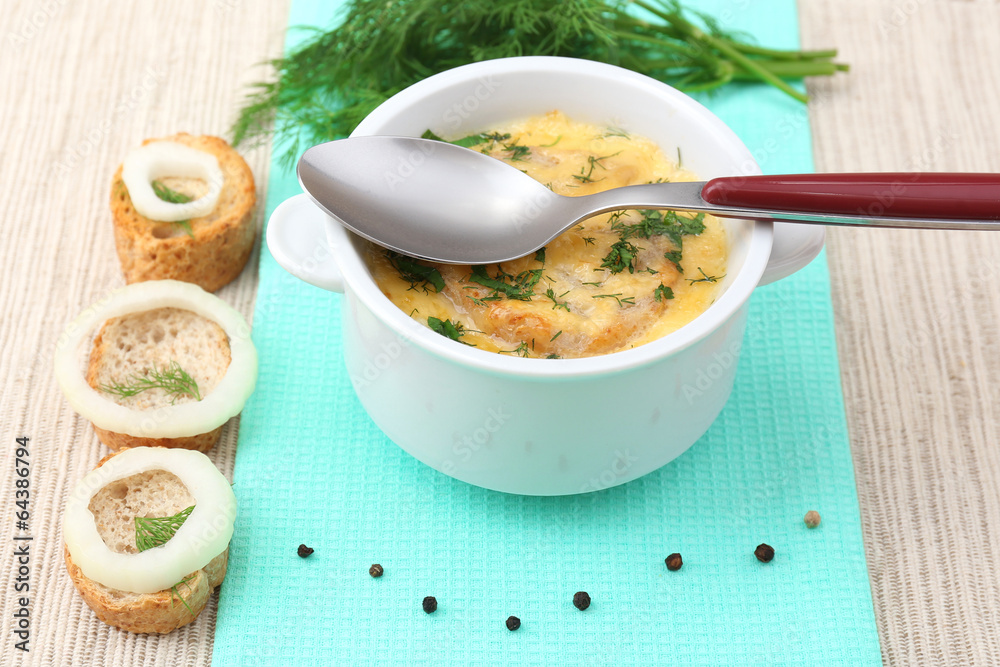Tasty soup in saucepan on tablecloth, close up