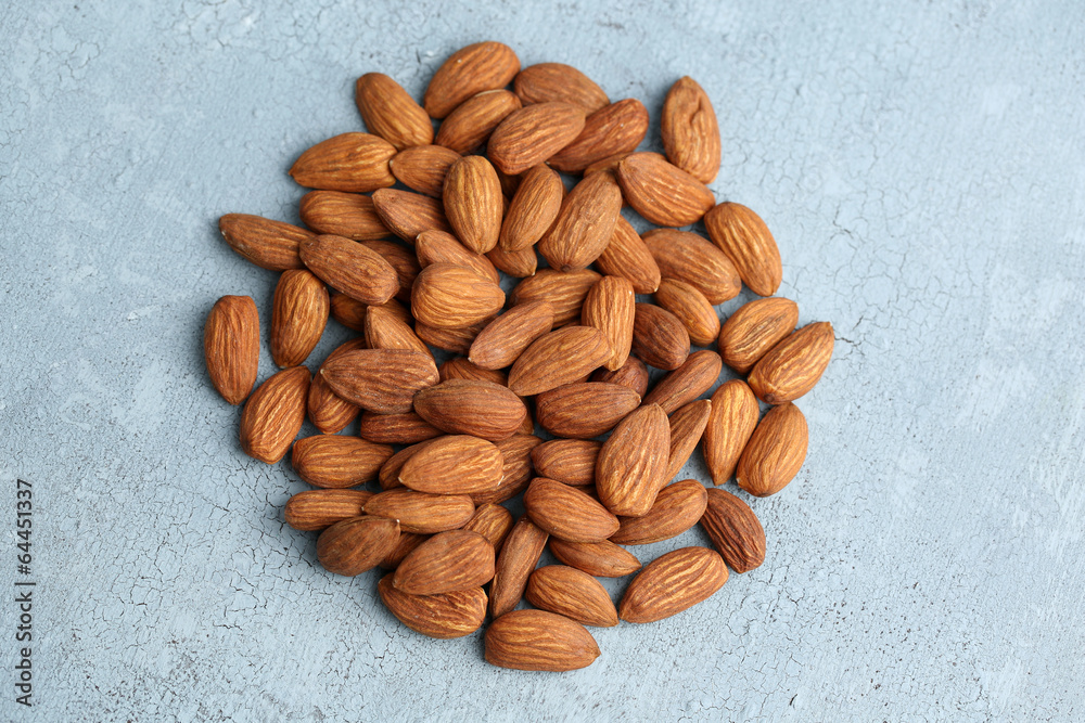 Almonds on color wooden background