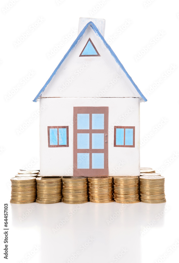 House standing on heap of coins isolated on white