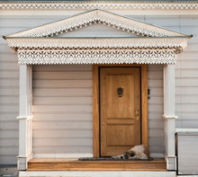 Newfoundland Sleeps Near  Door On Porch Of A Beautiful House