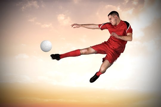 Fit football player playing and kicking
