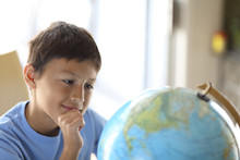 Young Boy Looking At A Globe