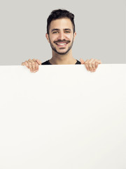 Wall Mural - Latin man holding a blank billboard