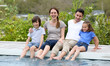 © goodluz - Parents with children relaxing by the pool