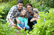 © goodluz - Portrait of happy family gardening together