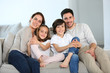 © goodluz - Happy family sitting together in couch