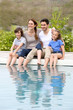 © goodluz - Parents with children relaxing by the pool