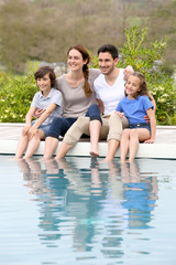 Wall Mural - Parents with children relaxing by the pool