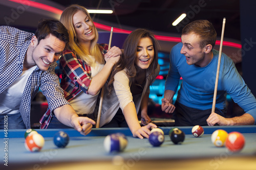 Fotografía Group of young friends playing billiard