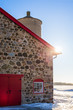 Old Stone Barn with Bright Red Door and Sunflare