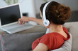 Backview of woman with headphones and laptop