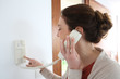 © goodluz - Woman inside home answering security phone