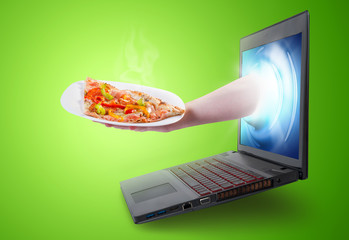 Hand holding a pizza slice coming out of a laptop screen