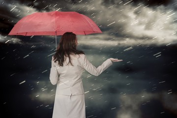 Poster - Composite image of businesswoman holding umbrella