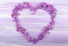 Beautiful Lilac Flowers In Shape Of Heart On Wooden Background