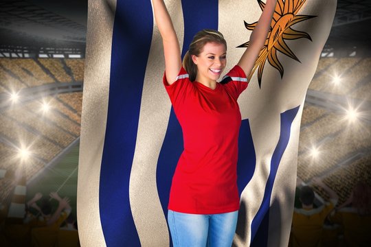 Cheering football fan in red holding uruguay flag