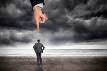 Poster - Giant hand pointing at businessman with hands on hips