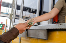 Man Paying Money At Toll Booth