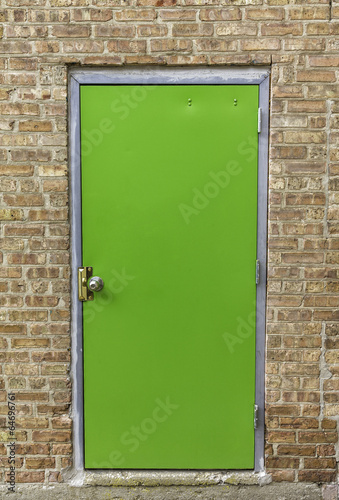 Obraz w ramie Green door on brick wall