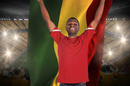 Excited handsome football fan cheering holding ghana flag