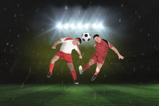 Football players tackling for the ball
